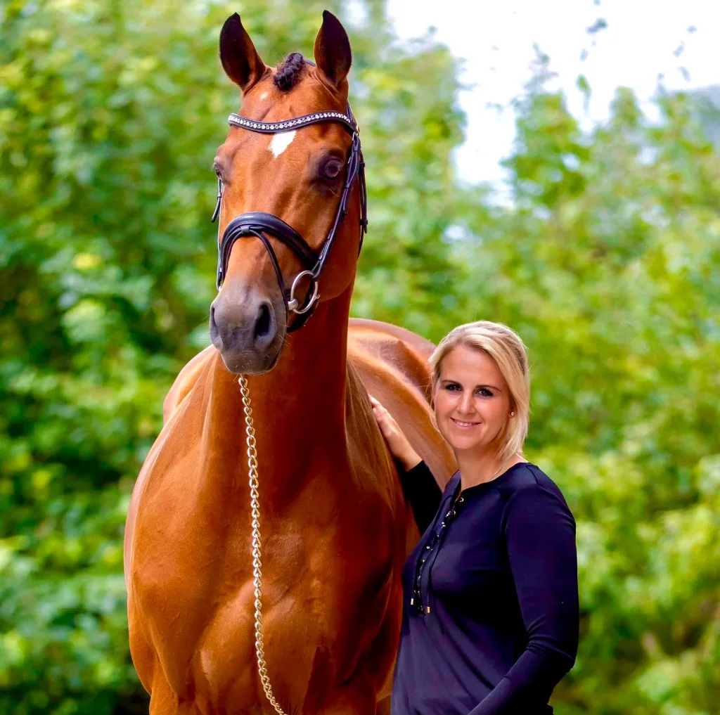 Lena Bieler mit einem braunen Pferd in Springausrüstung